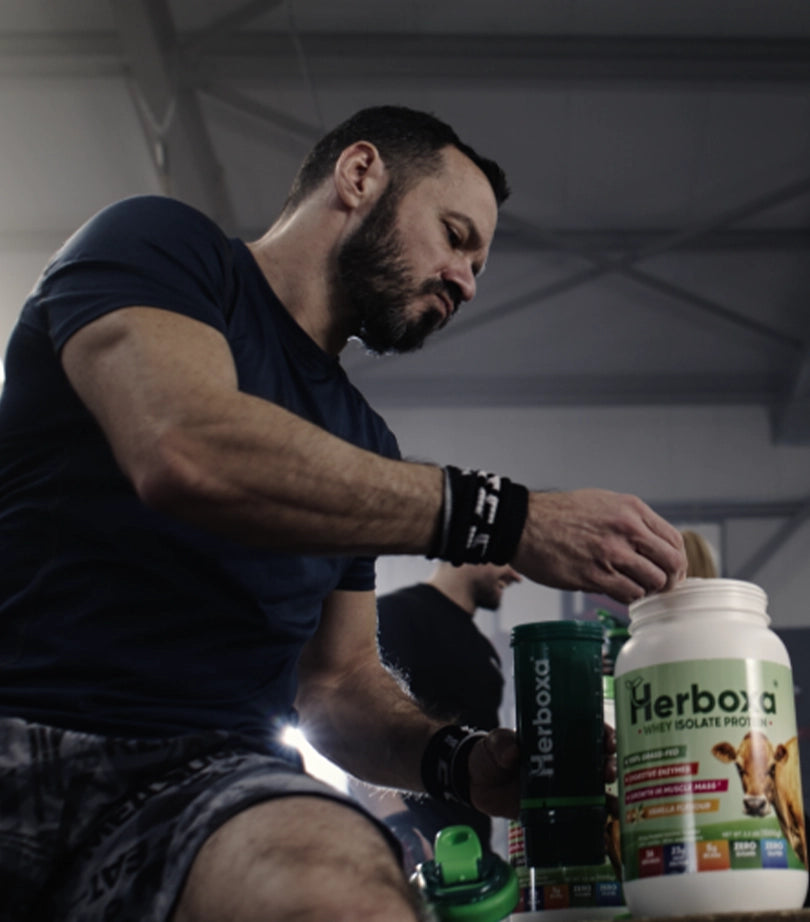 Man working out in the gym, preparing a Herboxa Whey Isolate Protein shake for muscle growth.